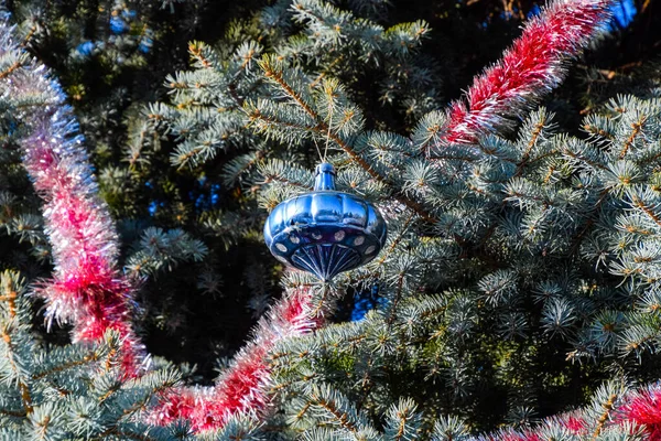 Decorazioni albero di Capodanno. Tagliatelle e giocattoli, palline e altre decorazioni sull'albero di Natale in piedi all'aria aperta . — Foto Stock