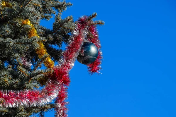 Δέντρο διακοσμήσεις νέο έτος. Στολίδια και παιχνίδια, μπάλες και άλλα στολίδια για τα Χριστούγεννα Χριστούγεννα δέντρο στέκεται στην ύπαιθρο. — Φωτογραφία Αρχείου