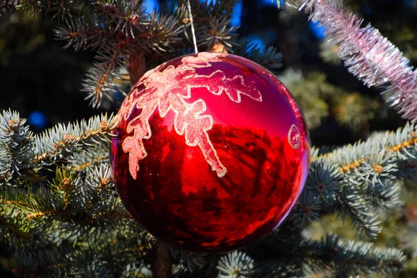 Decorações árvore de Ano Novo. Tinsel e brinquedos, bolas e outras decorações na árvore de Natal de pé ao ar livre . — Fotografia de Stock