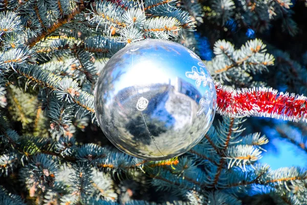 Decorações árvore de Ano Novo. Tinsel e brinquedos, bolas e outras decorações na árvore de Natal de pé ao ar livre . — Fotografia de Stock