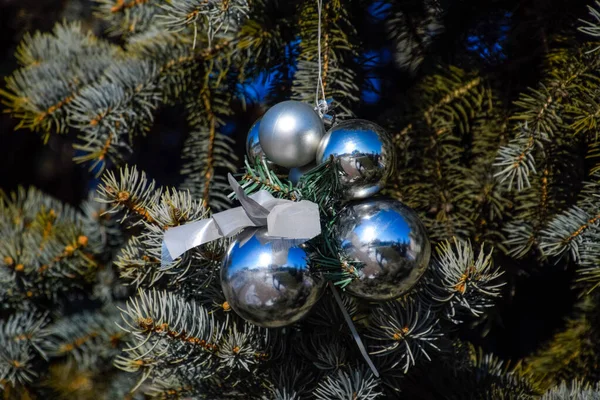 Decoraciones árbol de Año Nuevo. Hojalata y juguetes, bolas y otras decoraciones en el árbol de Navidad de pie al aire libre . — Foto de Stock