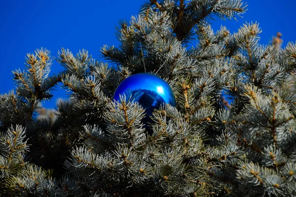Decorações árvore de Ano Novo. Tinsel e brinquedos, bolas e outras decorações na árvore de Natal de pé ao ar livre . — Fotografia de Stock