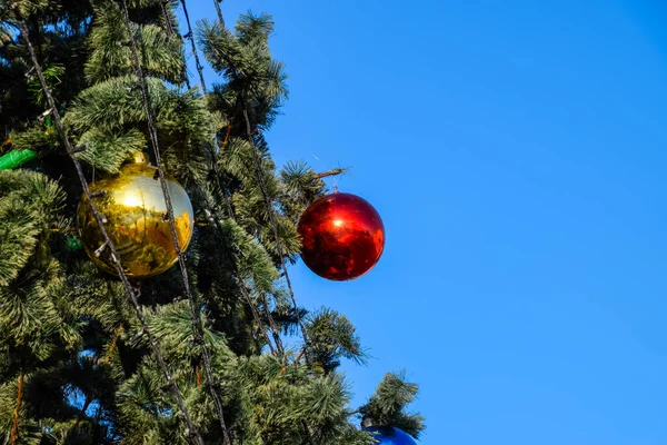 Decoraciones árbol de Año Nuevo. Hojalata y juguetes, bolas y otras decoraciones en el árbol de Navidad de pie al aire libre . — Foto de Stock