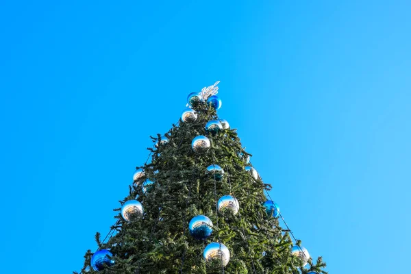 Decoraciones árbol de Año Nuevo. Hojalata y juguetes, bolas y otras decoraciones en el árbol de Navidad de pie al aire libre . — Foto de Stock