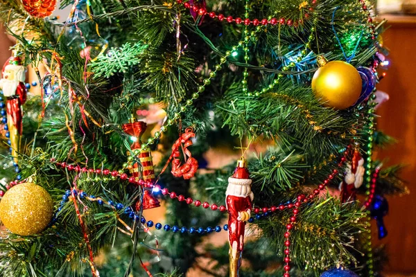 Decorações árvore de Ano Novo. Tinsel e brinquedos, bolas e outras decorações na árvore de Natal de pé ao ar livre . — Fotografia de Stock