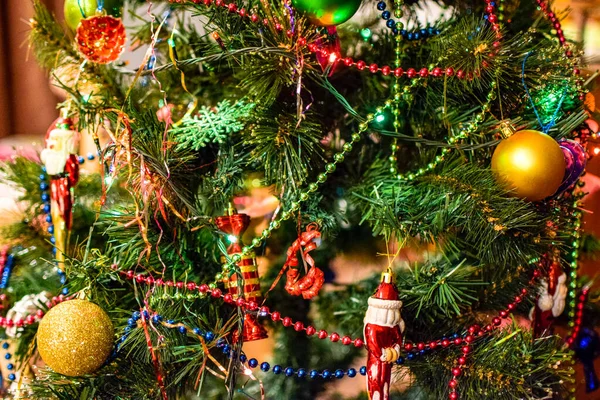 Decorações árvore de Ano Novo. Tinsel e brinquedos, bolas e outras decorações na árvore de Natal de pé ao ar livre . — Fotografia de Stock