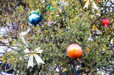 Süslemeleri yılbaşı ağacı. Tinsel ve oyuncaklar, topları ve diğer süslemeleri Noel Noel ayakta açık havada ağaç.