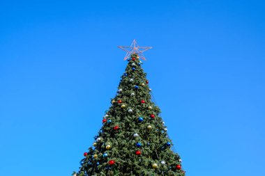 Süslemeleri yılbaşı ağacı. Tinsel ve oyuncaklar, topları ve diğer süslemeleri Noel Noel ayakta açık havada ağaç.