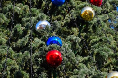 Süslemeleri yılbaşı ağacı. Tinsel ve oyuncaklar, topları ve diğer süslemeleri Noel Noel ayakta açık havada ağaç.