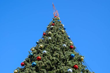 Süslemeleri yılbaşı ağacı. Tinsel ve oyuncaklar, topları ve diğer süslemeleri Noel Noel ayakta açık havada ağaç.