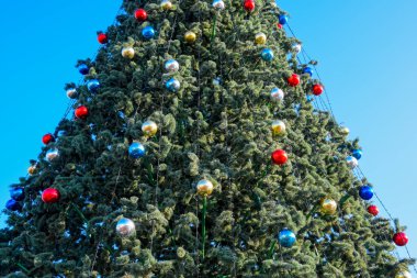 Süslemeleri yılbaşı ağacı. Tinsel ve oyuncaklar, topları ve diğer süslemeleri Noel Noel ayakta açık havada ağaç.