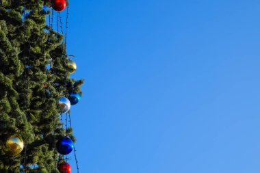 Süslemeleri yılbaşı ağacı. Tinsel ve oyuncaklar, topları ve diğer süslemeleri Noel Noel ayakta açık havada ağaç.