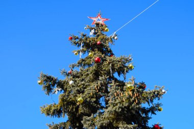 Süslemeleri yılbaşı ağacı. Tinsel ve oyuncaklar, topları ve diğer süslemeleri Noel Noel ayakta açık havada ağaç.