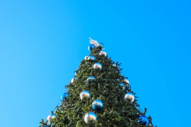 Süslemeleri yılbaşı ağacı. Tinsel ve oyuncaklar, topları ve diğer süslemeleri Noel Noel ayakta açık havada ağaç.