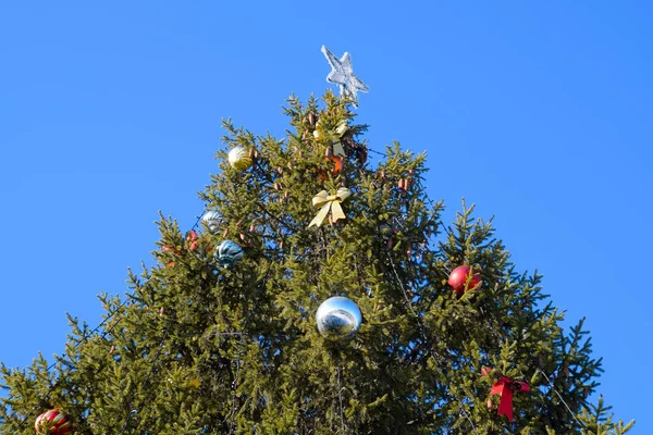 Süslemeleri yılbaşı ağacı. Tinsel ve oyuncaklar, topları ve diğer süslemeleri Noel Noel ayakta açık havada ağaç.