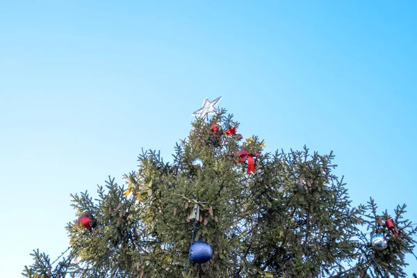 Decoraciones árbol de Año Nuevo. Hojalata y juguetes, bolas y otras decoraciones en el árbol de Navidad de pie al aire libre . — Foto de Stock