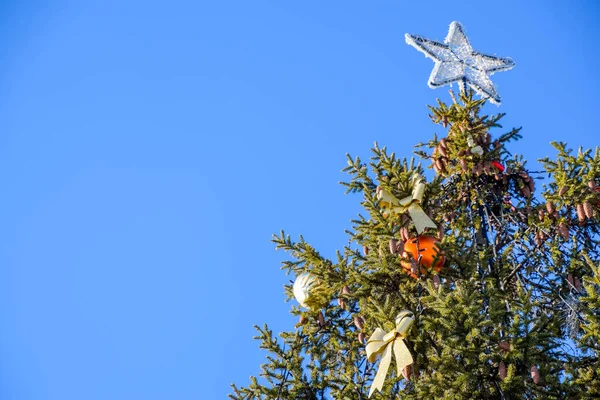 Decoraciones árbol de Año Nuevo. Hojalata y juguetes, bolas y otras decoraciones en el árbol de Navidad de pie al aire libre . — Foto de Stock