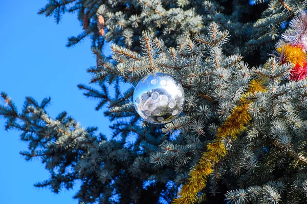 Dekorationen Neujahrsbaum. Lametta und Spielzeug, Kugeln und andere Dekorationen am Weihnachtsbaum im Freien. — Stockfoto