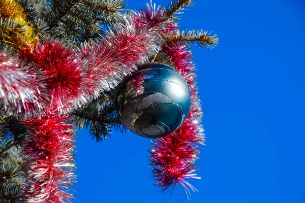 Dekorationen Neujahrsbaum. Lametta und Spielzeug, Kugeln und andere Dekorationen am Weihnachtsbaum im Freien. — Stockfoto