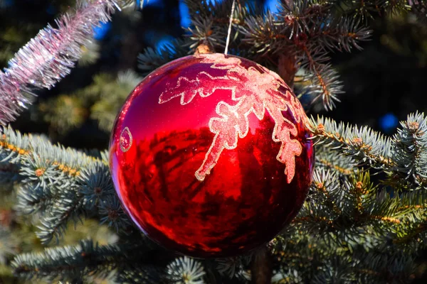 Decorações árvore de Ano Novo. Tinsel e brinquedos, bolas e outras decorações na árvore de Natal de pé ao ar livre . — Fotografia de Stock