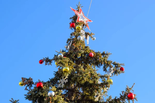 Decoraciones árbol de Año Nuevo. Hojalata y juguetes, bolas y otras decoraciones en el árbol de Navidad de pie al aire libre . — Foto de Stock