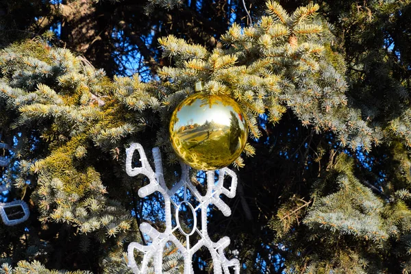 Украшения новогодняя елка. Тинзель и игрушки, шары и другие украшения на рождественской елке, стоящей на открытом воздухе . — стоковое фото