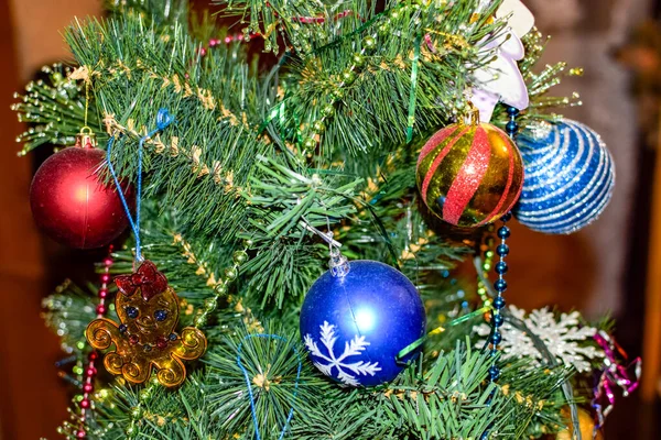 Decorações árvore de Ano Novo. Tinsel e brinquedos, bolas e outras decorações na árvore de Natal de pé ao ar livre . — Fotografia de Stock