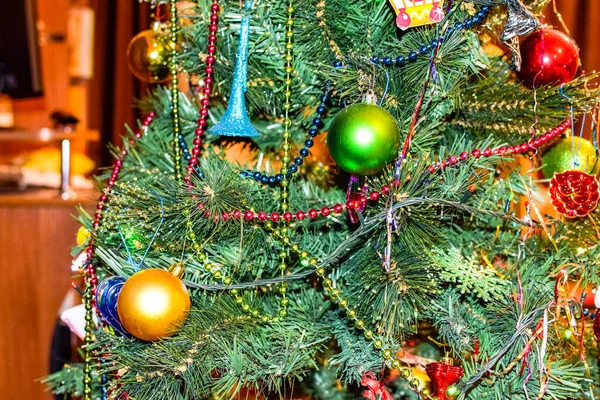 Decorations New Year tree. Tinsel and toys, balls and other decorations on the Christmas Christmas tree standing in the open air. — Stock Photo, Image