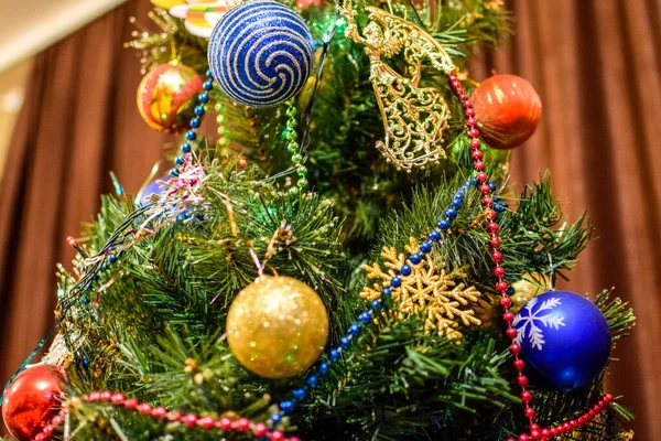 Decorações árvore de Ano Novo. Tinsel e brinquedos, bolas e outras decorações na árvore de Natal de pé ao ar livre . — Fotografia de Stock