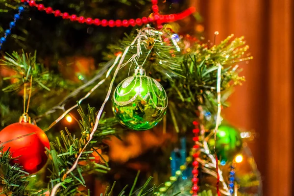 Decorações árvore de Ano Novo. Tinsel e brinquedos, bolas e outras decorações na árvore de Natal de pé ao ar livre . — Fotografia de Stock