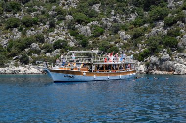 Turistler bir zevk yatının yanında denizde yüzerler. Akdeniz, Kekova ve Demre açıklarında..