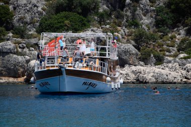 Turistler bir zevk yatının yanında denizde yüzerler. Akdeniz, Kekova ve Demre açıklarında..