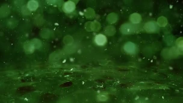 Winter grüne Bewegung Hintergrundbeleuchtung, Schnee fällt auf Eis defokussiert Bokeh-Schleife — Stockvideo