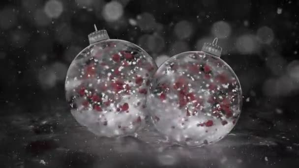 Två roterande White Ice glas julgranskulor snö röda kronblad bakgrund loop — Stockvideo