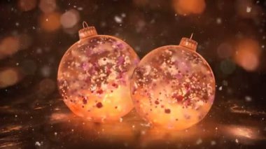 İki dönen Noel altın buz Baubles renkli yaprakları arka plan döngü kar