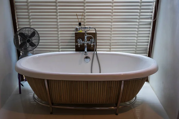 空白白色陶瓷浴缸与木小鸡盲背景和老电风扇 — 图库照片