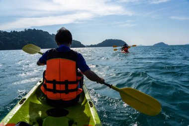 Asya ailesi açgözlülük ve kırmızı üzerinde kürek çekmeye mavi deniz ile anlaştık ve arka plan Adaları.
