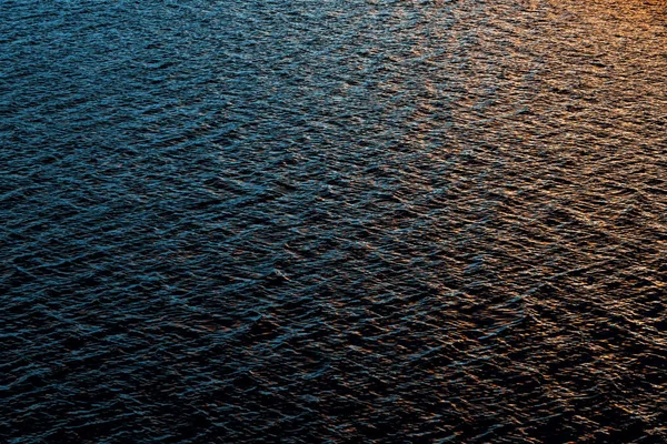 小さな動きの質感風の強い日の夕暮れ時 湖の青と金色の波紋をぼやけています — ストック写真