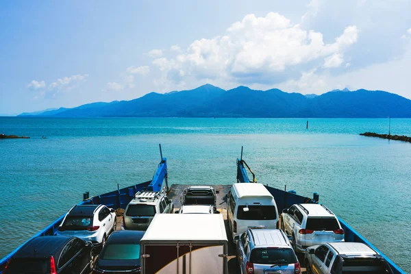 自動フェリー運ぶ車やトラックに遠い島の青い海を — ストック写真