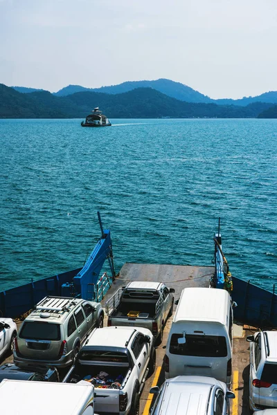 車が青い海を渡って島に運ぶ自動車をフェリーします — ストック写真