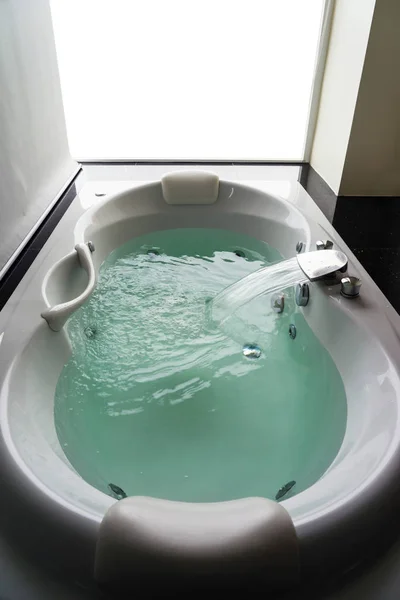 Banheira de hidromassagem branca vazia com água turquesa — Fotografia de Stock