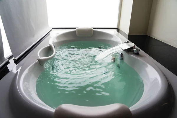 White massaging jetted bathtub with turquoise water and blank background — Stok fotoğraf