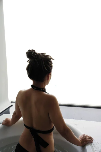 Asiatische Frau in der Badewanne Blick auf leere weiße Fensteransicht — Stockfoto