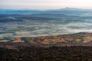 Tarım çiftlikleri ve sabah sis ile dağ sırası