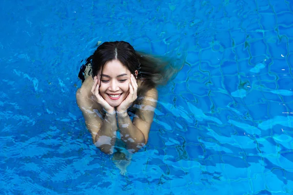 Asiatisk kvinna känner sig lycklig i Blue swimming pool — Stockfoto