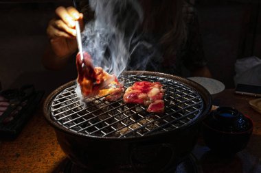 Hareket bulanıklık el ve chopsticks kömür ızgara sığır eti toplama