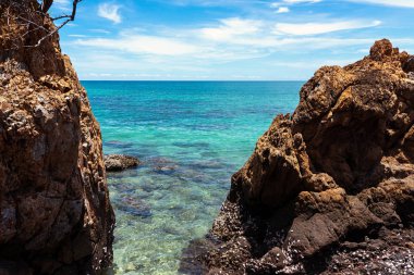 Gökyüzü ve ufuk ile berrak mavi denizde büyük taşlar