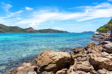 Berrak turkuaz deniz arka plan ile plajda büyük kayalar