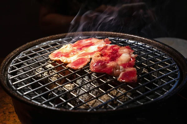 木炭烤架上的红色生牛肉，带烟 — 图库照片