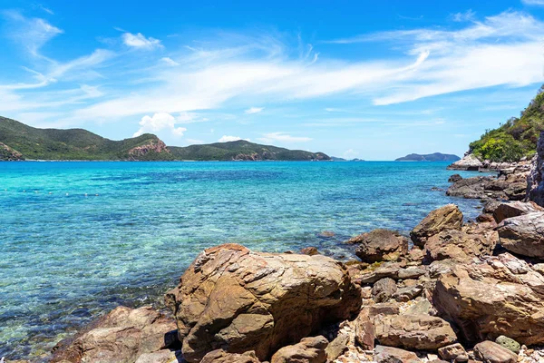 澄んだターコイズブルーの海の背景を持つビーチの大きな岩 — ストック写真